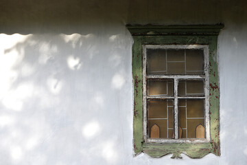 glass Window with old wooden frame. abandoned building. old window. finely broken glass. old house, retro. cracked window frame. cracked old paint, pieces of glass. white wall, space for text
