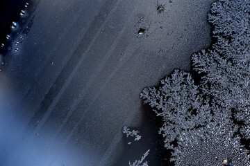 image of frost on the glass. Subzero temperatures outside. Crystals of frozen water on glass, in the sun's rays. Beautiful pattern of frost on the window glass. ice, for text or image as background