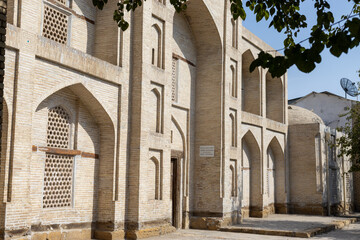 General view of the Rashid Madrasah in Bukhara, Uzbekistan. Old building from baked brick. Translation: Cultural heritage site, Rashid Madrasah, 18th-19th centuries, Protected by the state