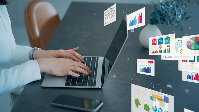 Image of a woman using a laptop and business documents