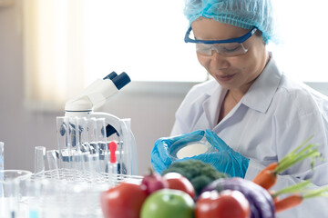 Fresh fruits and vegetables are placed beside colorful test tubes in a modern laboratory, where a food scientist conducts research on nutrition, food safety, and organic quality testing under a micros