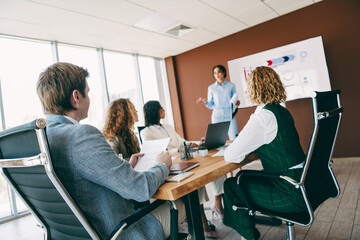 Business professionals collaborating in a modern office during a meeting focusing on teamwork and corporate development