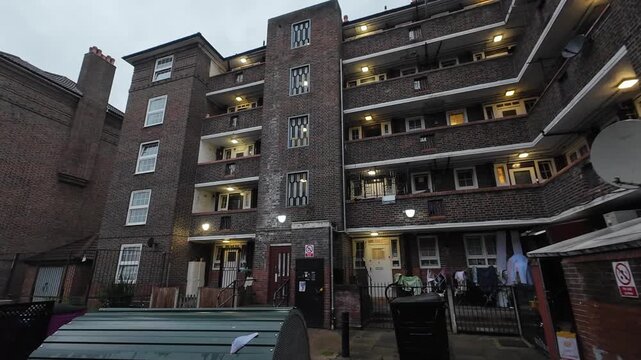 A pan clip of a government social housing estate in London of a dated construction during a grey Autumn late afternoon.