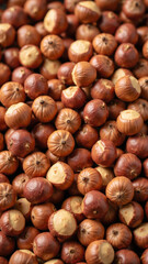 Obraz premium Fresh hazelnuts scattered on surface, showcasing their rich brown color and unique texture, perfect for culinary uses and healthy snacking