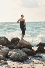 Young woman enjoying the summer breeze in a slip dress at Miami beach