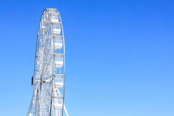 Giant ferris wheel against clear blue sky on a sunny day
