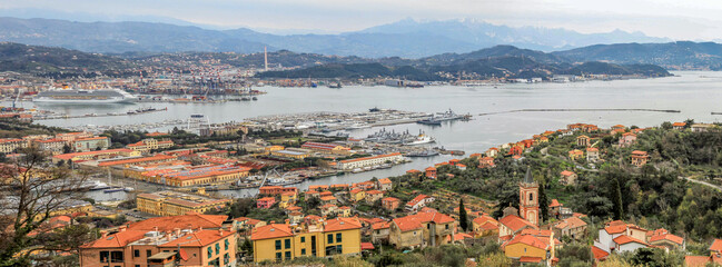 Panoramic view of the harbor and town of La Spezia with cruise ships and mountains in the background, Italy