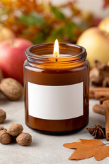 Warm autumn candle surrounded by apples, nuts, and spices creating a cozy atmosphere in a rustic setting