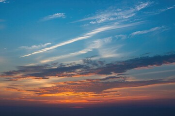 Fototapeta premium As the sun sets gently, the sky becomes a masterpiece of fiery reds, shimmering golds, and deep purples stretching wide.