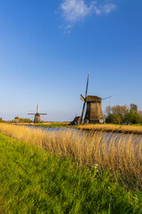 Historical windmills standing by waterway in North Holland, Netherlands