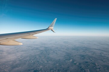 Fototapeta premium Aircraft Wing Above Snowy Landscape