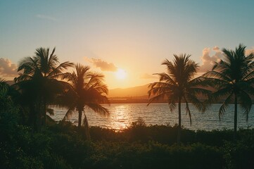 Obraz premium Tropical sunset with orange sky and palm silhouettes over water