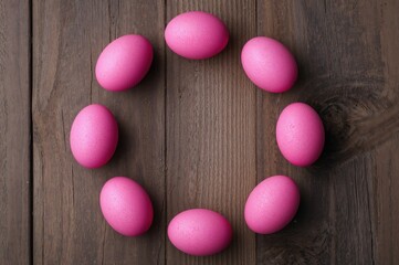 Obraz premium Happy Easter concept with pink eggs on a wooden surface
