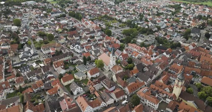 Aerial view of the rustic town featuring the Schriesheim Church with its tall steeple, nestled among terracotta rooftops and lush greenery, Schriesheim, Baden-Wurttemberg, Germany.