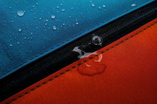 Close-up of water droplets on waterproof fabric and zipper, designed to resist moisture and facilitate easy cleaning