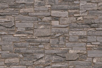 Fototapeta premium Contemporary textured stone brick wall designed as a backdrop.