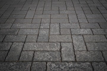 Close-up of stone pavement with a textured gray backdrop
