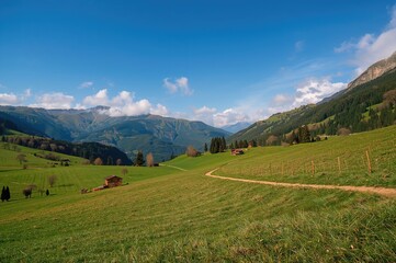 Fototapeta premium Scenic Valley View Featuring a Cottage and Meandering Trail