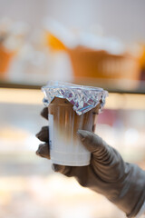 hand of woman holding a take-out iced with blurred bokeh blackground, isolate concept.