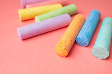 Colored chalks for drawing on pink background flat lay top view. School chalks, back to school, concept of development and education of children, toddlers, art, child activities