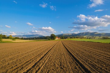 Field ready for sowing with a home visible in the distance