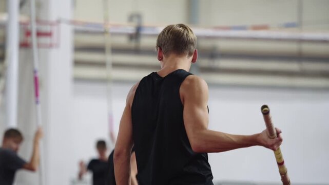 Young male pole vaulter preparing to jump