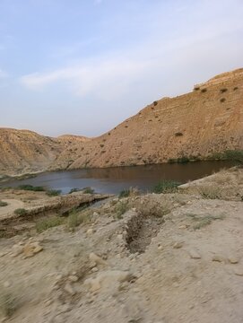 A Black dead valley under a blue sky between the large mountains, it's Zain Koh e sulaiman Barthi road