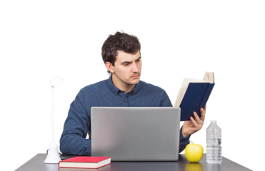 Focused young male student seated at the working desk in front of a laptop studying carefully from a book. Hard learning male looking for answers in a book, isolated portrait on transparent background