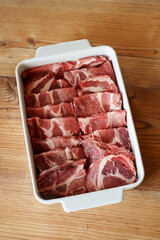 Raw pork meat in white ceramic dish