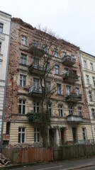 Fototapeta premium Historic Building Facade: The facade of an aged building stands, showcasing detailed architectural design elements, and brickwork, and hinting at a rich history, offering a glimpse into the past.