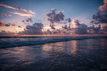 Obraz premium Extended exposure capturing clouds above the sea and their reflections in clear tropical waters, perfect for stunning dawns or dusks.
