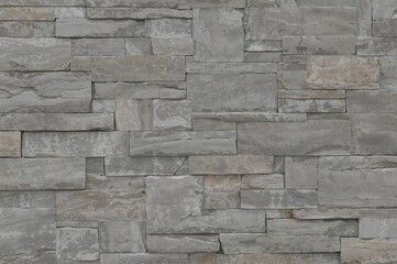 Obraz premium Gray artificial facing stone wall with a rough texture