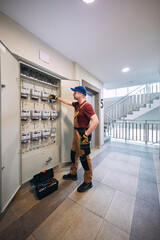 Electrician working on a modern electricity power meter station in a building.