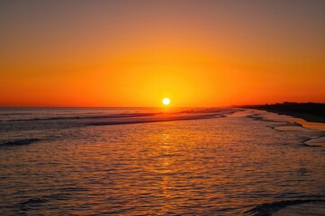 Obraz premium Golden sunset glow with serene sea and vivid horizon - peaceful silhouette at dusk over still waters