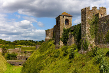 View across the grassy moat towards the medieval walls of historic Dover Castle, England