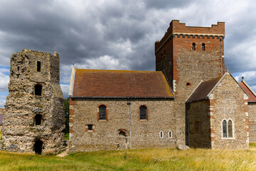 Dramatic cloudy sky over the ancient Saxon church and Roman lighthouse in Dover, UK