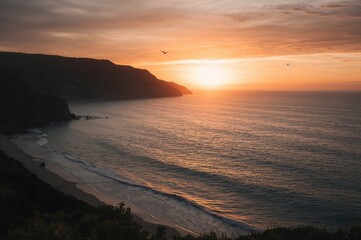 Fototapeta premium Sunset over tranquil hills embracing the ocean is beautiful, created with AI generative tools