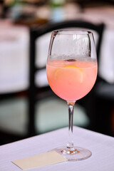 A glass of prosecco rosé on the table against a bokeh restaurant background