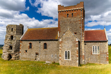 Fototapeta premium Historic Saxon church and Roman pharos ruins on a grassy hill in Dover, England