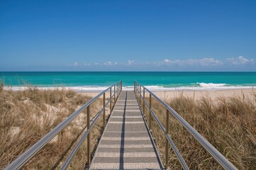 Fototapeta premium Beachside accessible path featuring metal railings for wheelchairs