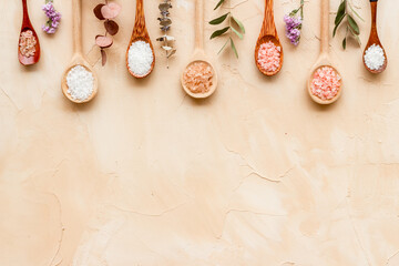 Naklejka na ściany i meble Beauty spa therapy cosmetics and wellness flat lay - sea salt in many spoons with flowers, top view