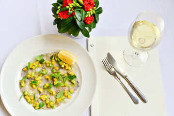 fish carpaccio garnished with corn and basil