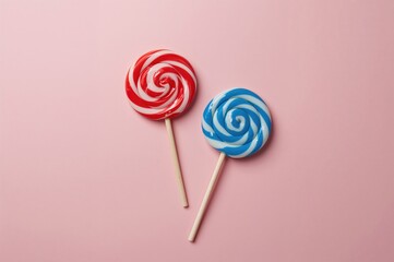 Two vibrant circular lollipops on sticks resting against a gentle pink backdrop in a vertical layout.