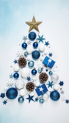 Festive arrangement of blue and white Christmas decorations, including ornaments, stars, and gifts, creatively shaped into a Christmas tree design for holiday celebrations