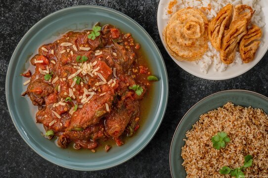 Fiery beef curry with brown rice, served with Ghee rice, Appam, Parotta, and Puttu in a traditional feast style.
