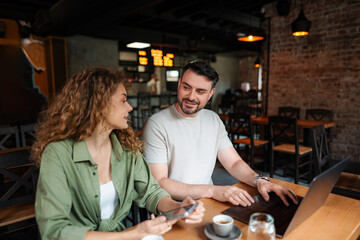 Young entrepreneurs working together on a laptop in a cafe