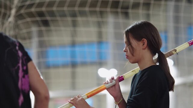 Young female athlete preparing for pole vaulting