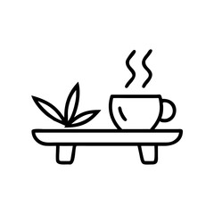 Bamboo tray with steaming tea cup and green plant accent  