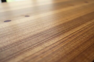 Close-up view of a polished wood surface exhibiting a rich, warm tone and subtle grain patterns