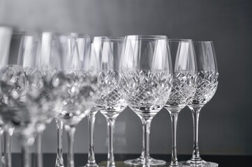 Close-up of lined-up wine glasses against a neutral backdrop